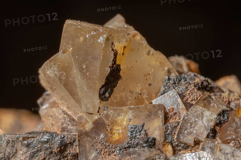 Bright, square crystals are visible on a piece of rock. The light underlines their structure and color. This mineral formation is fascinating and fascinating