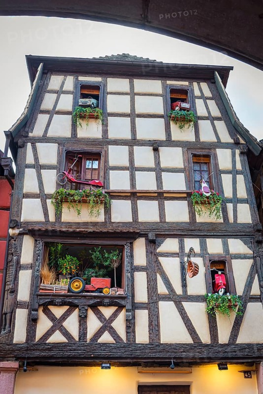 Timber-frame house decorated with vehicles in the historic old town of Riquewihr, Ellsass