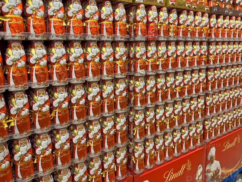 Display on the shelf of chocolate Santa Claus chocolate Santa Claus Santa Claus Santa Claus Santa Claus chocolate Santa Claus chocolate Santa Claus chocolate lice Santa Claus chocolate lice Santa Claus in color red of red staniol paper made of chocolate arranged like army of Santa Claus, Germany