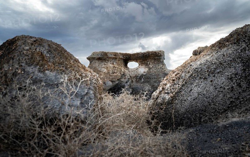 Eroded rock formations with rock tunnels, volcanic landscape with dramatic cloudy skies, Ciudad Estratificada or Los Roferos, Antigua Rofera de Teseguite, Lanzarote, Canary Islands, Spain