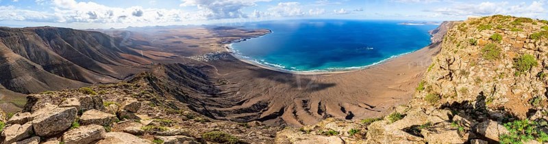 Panorama at Castillejo viewpoint, view from the Risco de Famara cliffs to the coast and the sea with Famara beach, Playa de Famara with La Calaeta, Lanzarote, Canary Islands, Spain