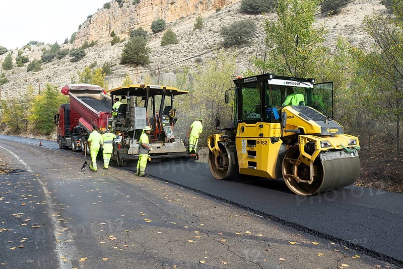Asphalt road construction team of workers resurfacing tarmac in rural area, near Albarracin, Teruel province, Aragon, Spain