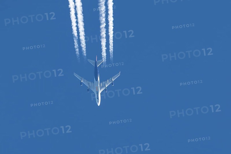 Boeing 747 jumbo jet cargo aircraft of Atlas air airlines flying in a blue sky with contrails or vapour trails behind, England, United Kingdom