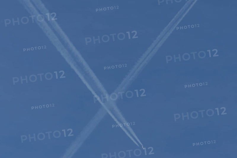 Aircraft contrails or vapour trails crossing in a blue sky, England, United Kingdom