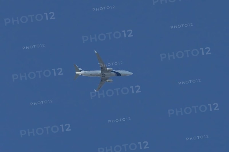 Boeing 737 jet passenger aircraft of El Al Israel airlines flying in a blue sky, England, United Kingdom