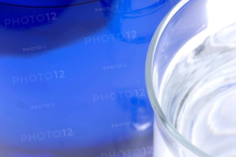 Glass with mineral water, small carbonated pearls on the edge of the glass, drinking water