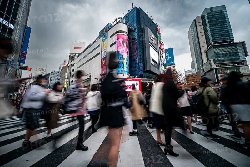 Crowd crossing zebra crossing on a large intersection, motion blur, back modern houses with colorful neon signs, long exposure, Shibuya Crossing, Shibuya, Tokyo, Japan
