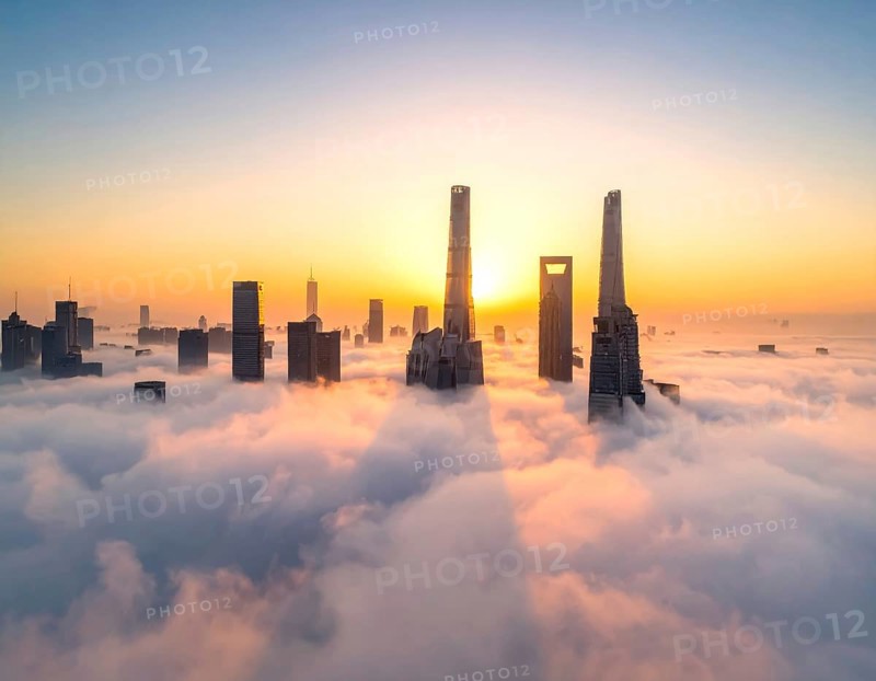 City scape emerging from a dense enveloping fog in sunrise and skyscrapers piercing the haze, big metropolis with skyline, mist on ground, blue sky, city in an aerial view, AI generated