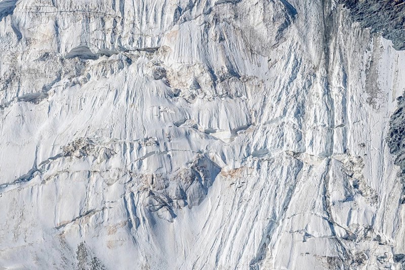 Intricate patterns of ice and rock are showcased in this stunning glacial landscape, revealing the effects of time on the frozen surface. The bright daylight emphasises the textures and colours. Gorner Glacier, Zermatt, Valais, Alps, Swiss
