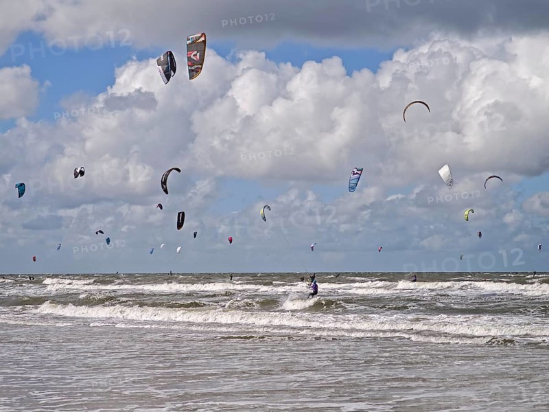 California kitesurfing Masters 2025 on the edge of the UNESCO World Heritage Wadden Sea, North Sea, kitesurfing sport, flying kites, fun, competition, strong wind, high swell, whitecaps, beach, summer, sunshine, blue sky, white clouds, Ording, Sankt Peter-Ording, Schleswig-Holstein, Germany