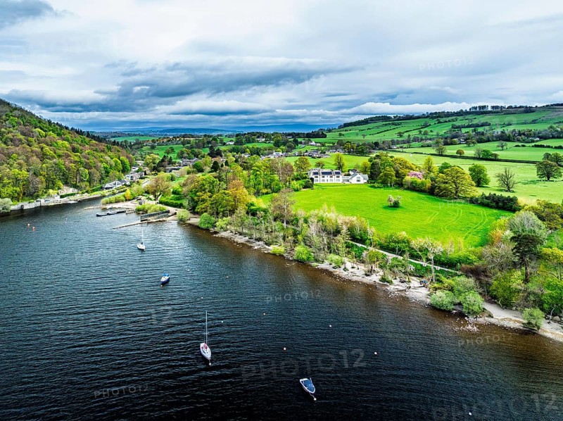 Farms and mountains over Ullswater Lake from drone, Pooley Bridge, Lake District National Park, Cumbria, England, United Kingdom