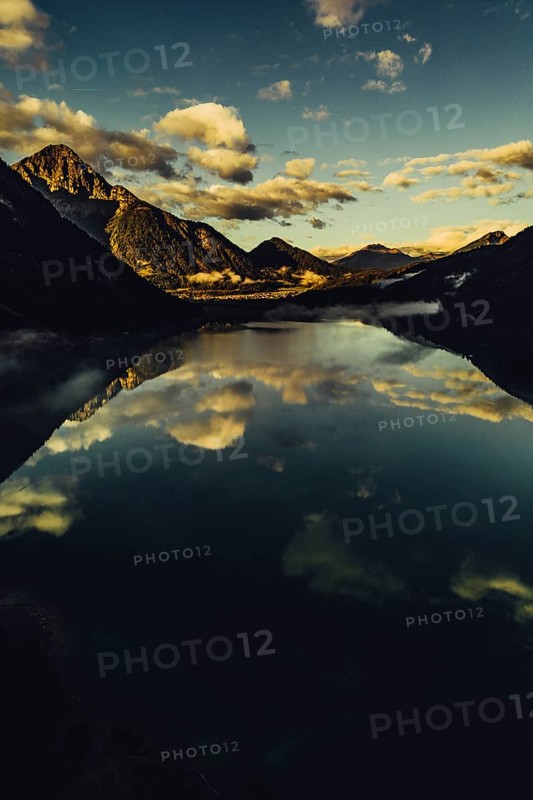 Sunrise with reflections and alpenglow in Lake Heiterwanger See in Tyrol in the Alps in Austria