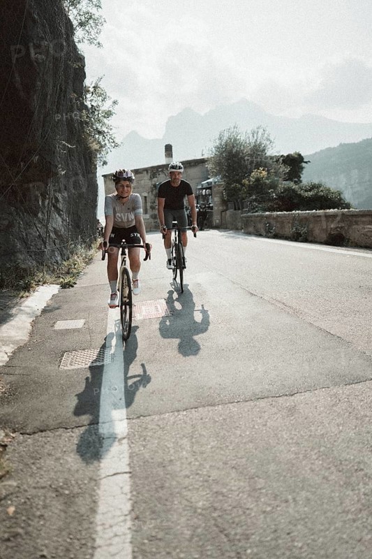 Woman and man riding racing bikes in Italy on Lake Garda