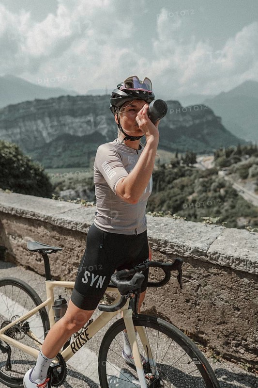 Young woman riding a racing bike on Lake Garda. Sunny weather and dolce vita