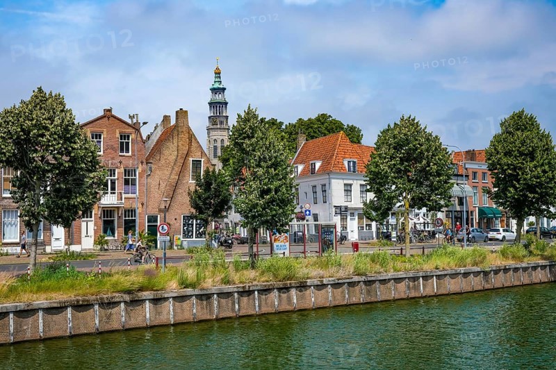 Middelburg, Zeeland, Netherlands - Townhouses on the Turfkaai at the Binnenhaven in the historic city centre. At the back is the Tall John Abbey Tower, a restored church tower from the 14th century with 207 stone steps leading to a viewing gallery