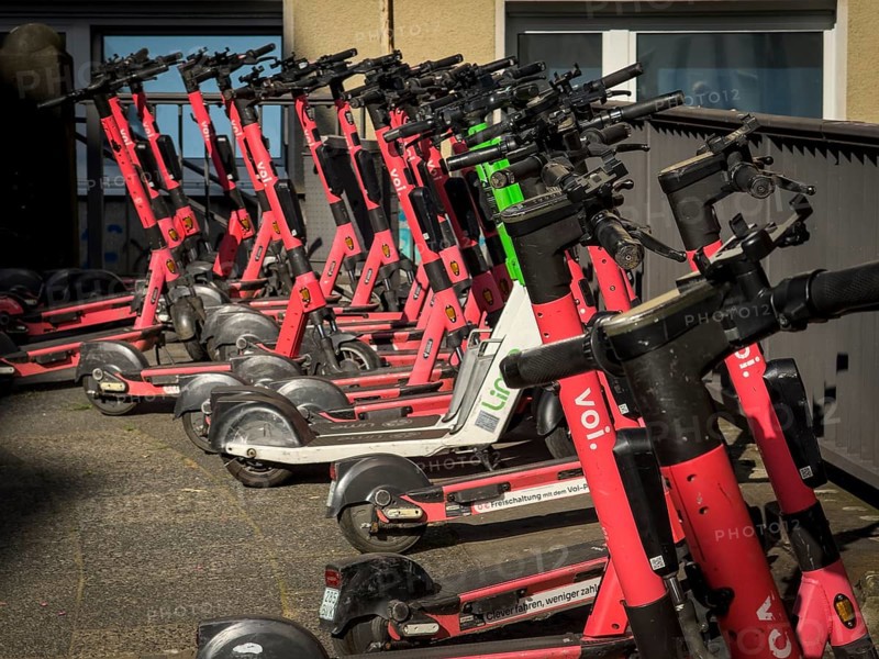 Many rental e-scooters parked on a pavement in Wuppertal, Germany