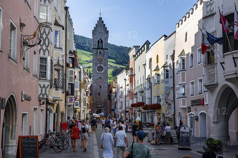 Old town, colourful houses in the main street, Zwölferturm tower at the back, old town, Sterzing, South Tyrol, Italy
