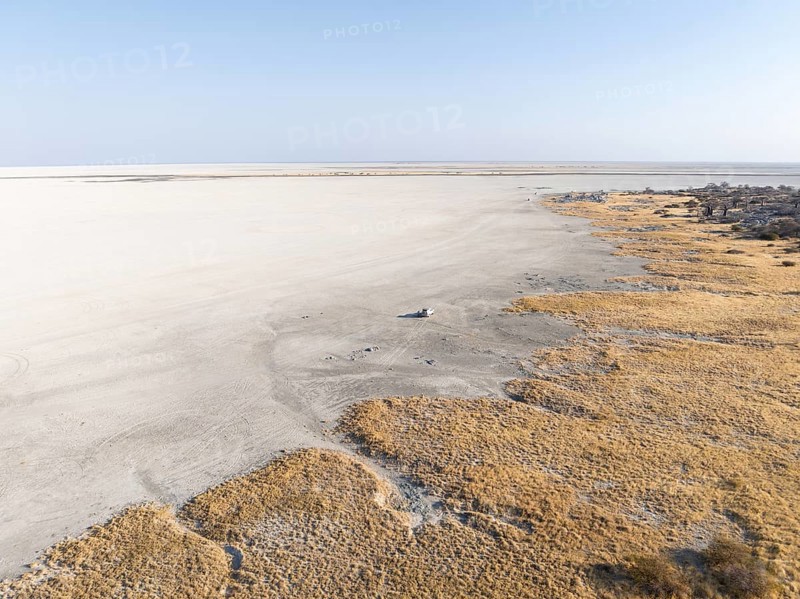 Rocky island with baobab trees in a dry salt pan, off-road vehicle on the salt pan, aerial view, Kubu Island, Sowa Pan, Makgadikgadi salt pans, Botswana