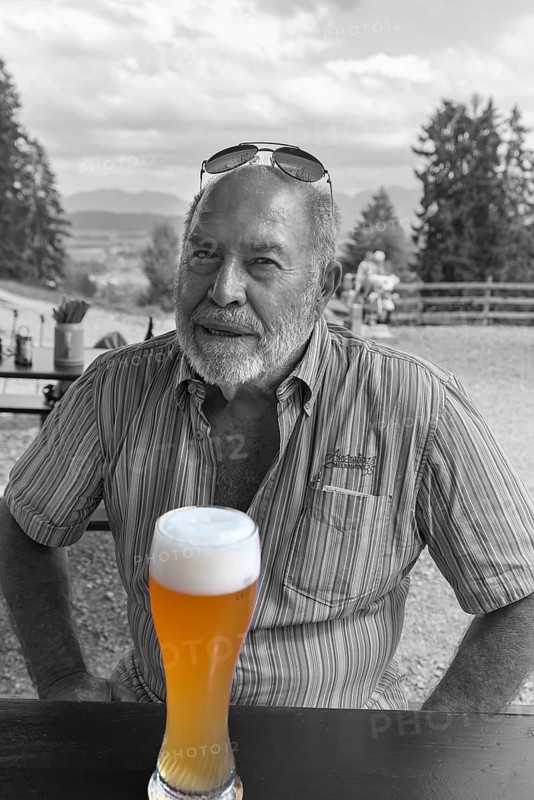 Elderly gentleman with beard and sunglasses in a garden restaurant with a drink, black and white, Bavaria, Germany