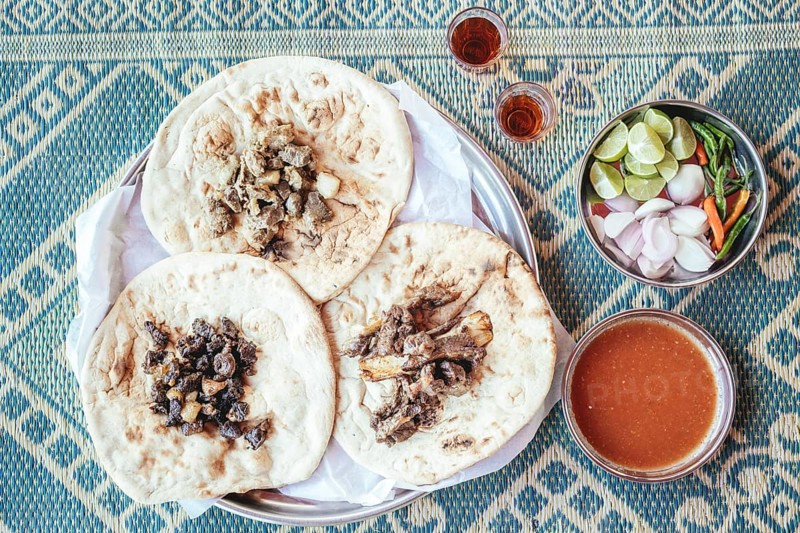 Traditional camel restaurant in Salalah, three kinds of camel meat (dry braised, boiled and grilled/baked), traditionally served with bread and chutney, Dhofar, Oman