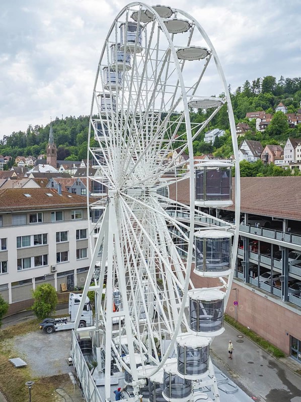A large Ferris wheel in an urban environment with a cloudy sky, Ferris wheel construction for the 950th anniversary of the city of Calw, Black Forest, Germany