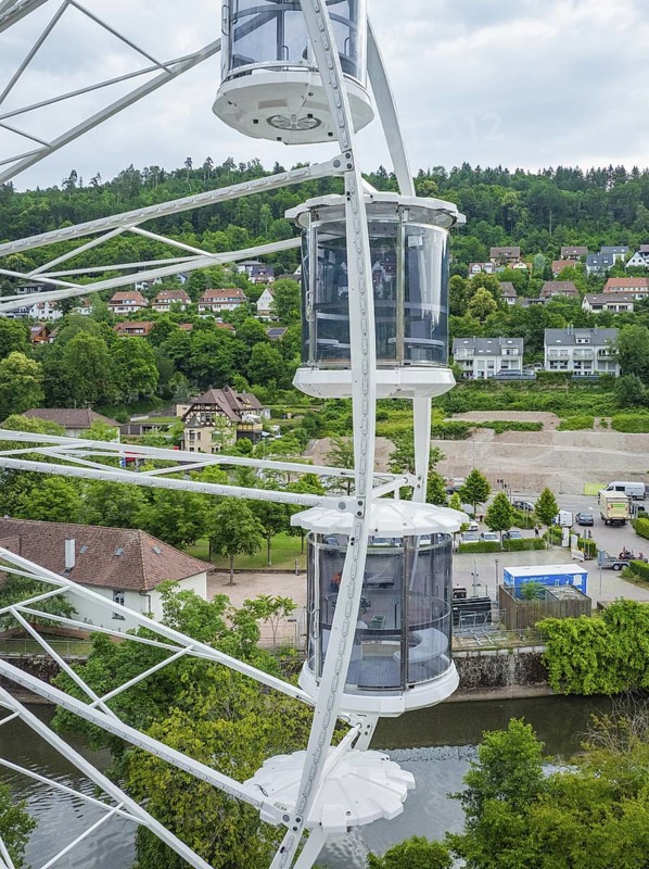 View from a Ferris wheel onto a cityscape with lots of greenery and houses, Ferris wheel construction for the 950th anniversary of the town of Calw, Black Forest, Germany