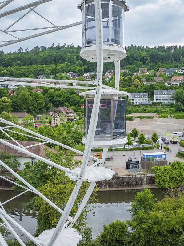 Ferris wheel view of a river, surrounded by green hills and a cityscape, Ferris wheel construction for the 950th anniversary of the town of Calw, Black Forest, Germany