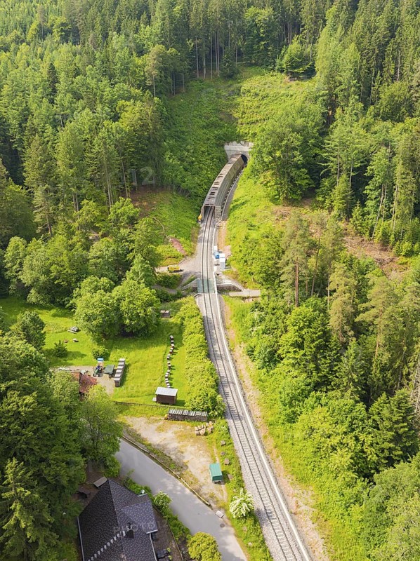 Aerial view of a railway tunnel running through a green, wooded landscape, construction of the Hermann Hesse Railway, Calw, Germany