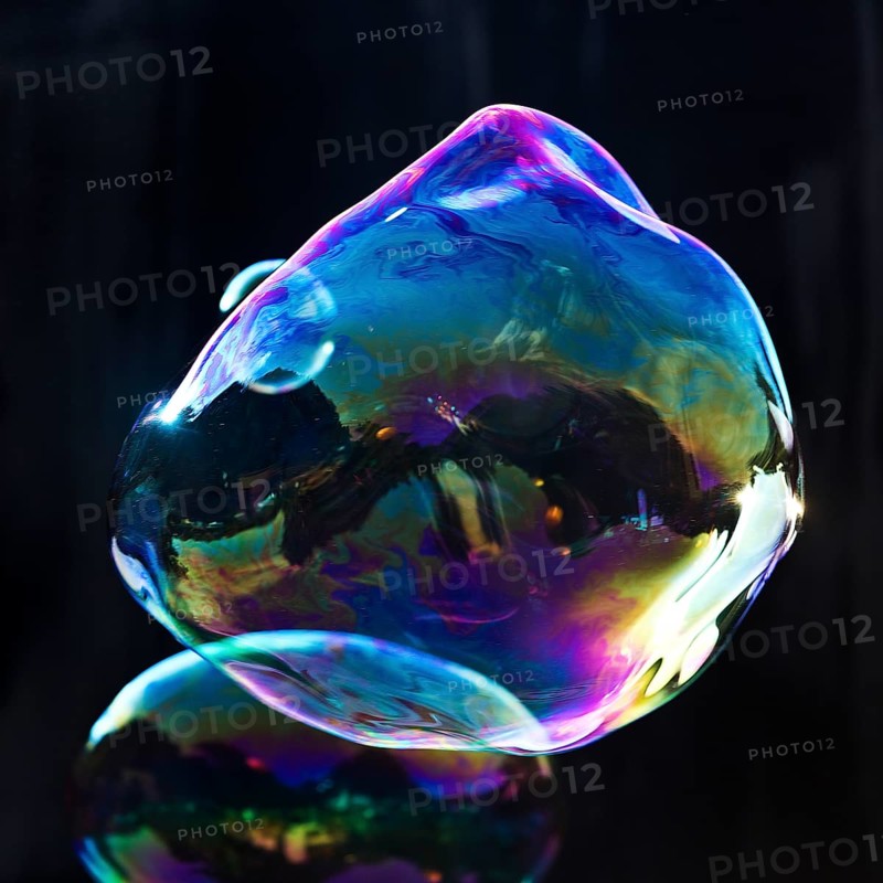 Large, irregular, iridescent soap bubbles in the colours of the rainbow against a black background, Recklinghausen, Germany