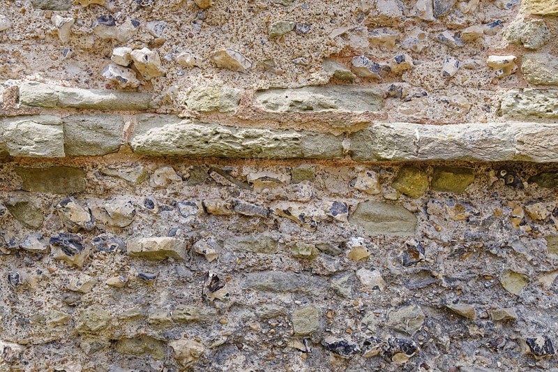 Masonry of the historic castle wall of Pevensey Castle, a Norman castle, in the village of Pevensey, Sussex, England, Great Britain