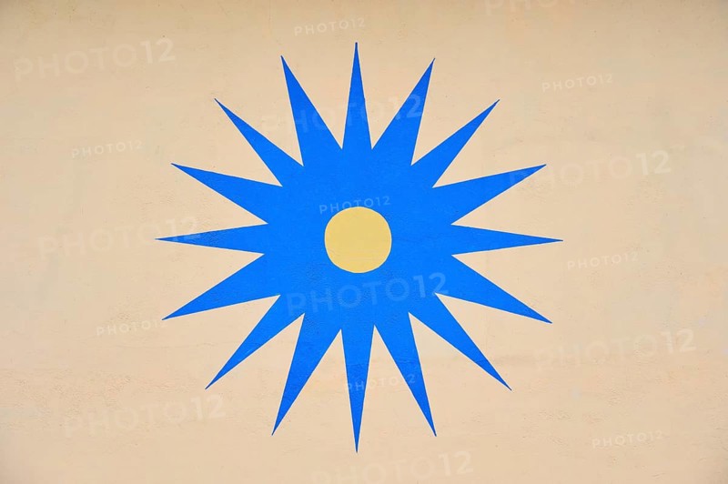 Blue stylised star with yellow centre on beige background, Rüdesheim am Rhein, Rhine Valley, Rheingau-Taunus-Kreis, Hesse, Germany