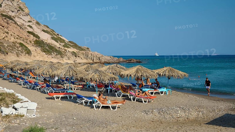 Sandy beach beach with sun loungers and parasols, surrounded by rocky hills, Agios Stefanos Beach, Agios Stefanos Basilica, Agios Nikolaos Chapel, Kastri Island, Kos, Dodecanese, Greek Islands, Greece