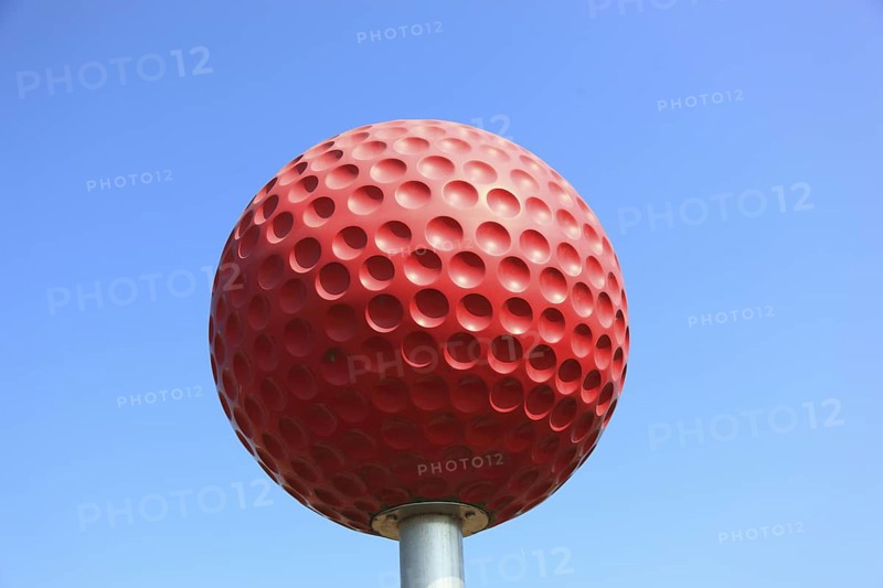 Large red golf ball to advertise a golf course