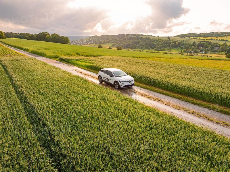 A modern car on a path through agricultural fields under a cloudy sky, Deer E- CarSharing, Renault Megane electric car, Calw, Black Forest, Germany