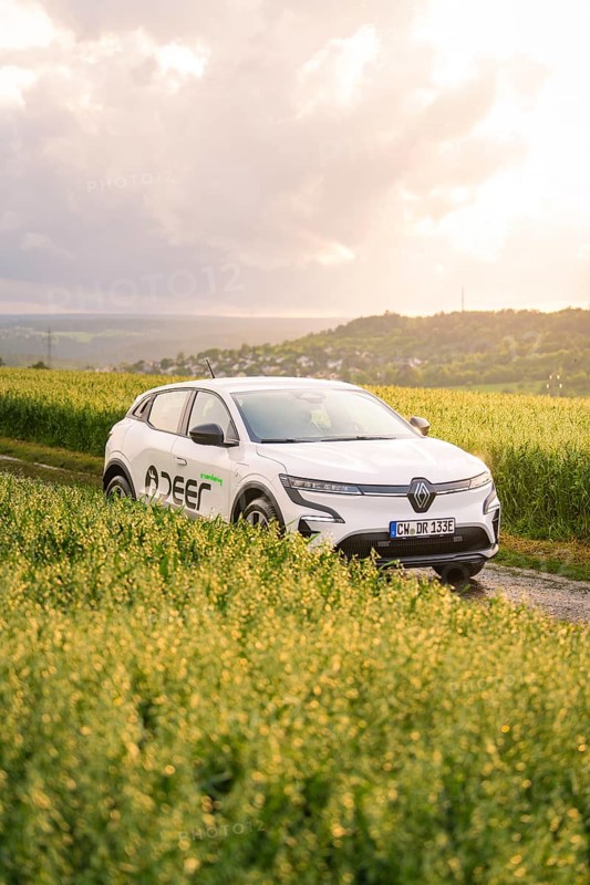 Car next to a field in a hilly landscape at sunset, Deer E- CarSharing, Renault Megane electric car, Calw, Black Forest, Germany