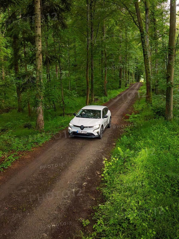 Car on a green forest path, surrounded by dense forest, Deer E- CarSharing, Renault Megane electric car, Calw, Black Forest, Germany