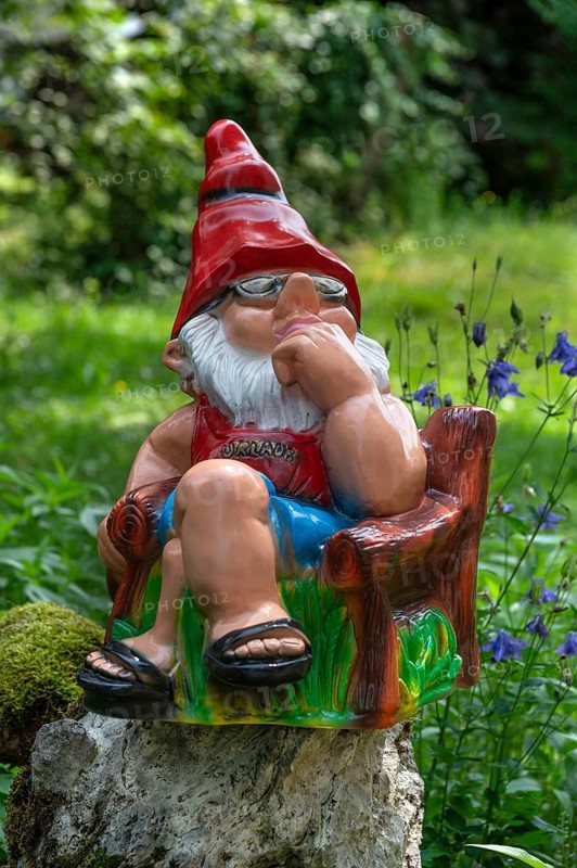 Sitting garden gnome in a garden, Bavaria, Germany
