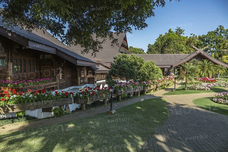 Ornate trees and lush flower gardens enhance the Lanna and Swiss architecture of the Doi Tung Royal Villa inside the Doi Tung tourist attraction in Chiang Rai, Thailand