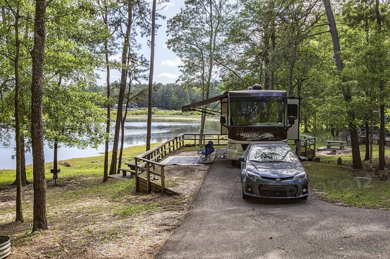 Motorhome parked in a campsite on the bank of the lake at Little Black Creek campground near Lumberton, Mississippi