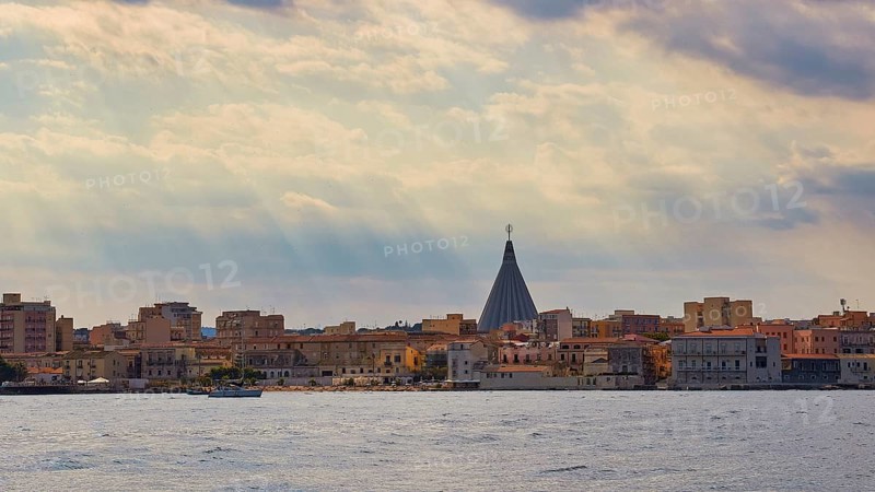 City with striking church spire under a cloudy sky over the sea, boat trip around the island of Ortigia, Isola di Ortigia, Syracuse, Sicily, Italy