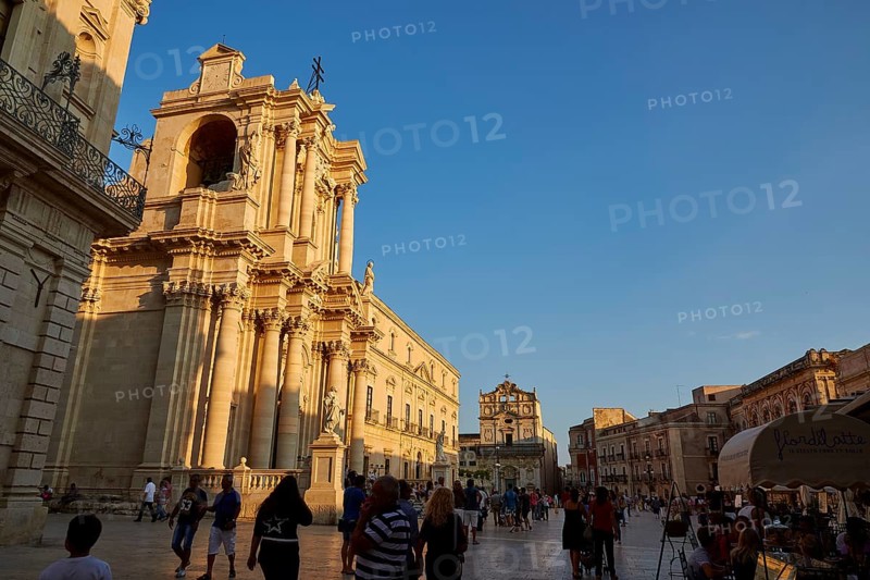 Cathedral of Syracuse, people strolling by an impressive cathedral on a square at sunset, Ortigia Island, Isola di Ortigia, historic old town, Syracuse, Sicily, Italy