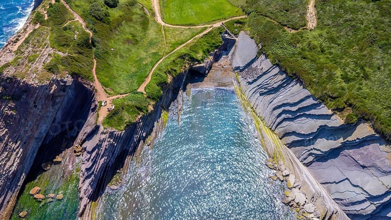 Aerial view of the impressive flysch cliffs of zumaia, basque country, spain, meeting the cantabrian sea during a sunny summer day, Spain.