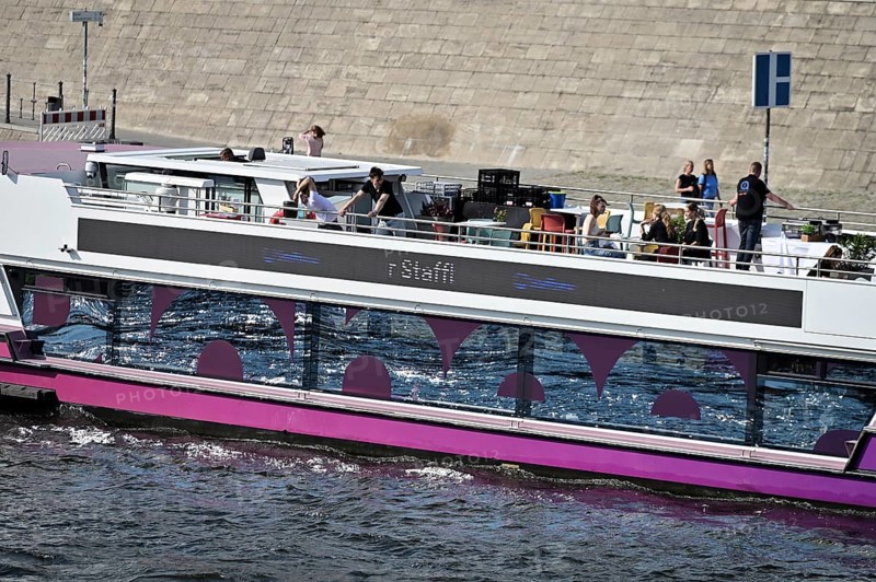 The media ship The Pionieer One sails on the Spree near the Kapelleufer