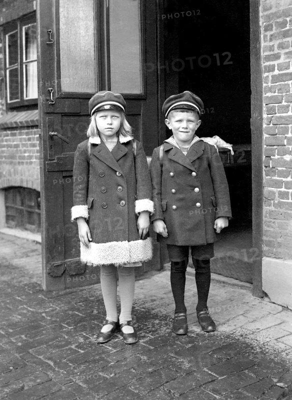 Brother sister pupil, 1920s, Two children in old-fashioned clothes stand seriously in front of an entrance, Historical photo
