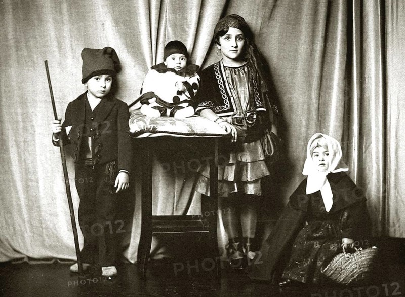 Children dressed up, 1910s, Four children in traditional costumes in front of a curtain, Group portrait in nostalgic style, Historical photo