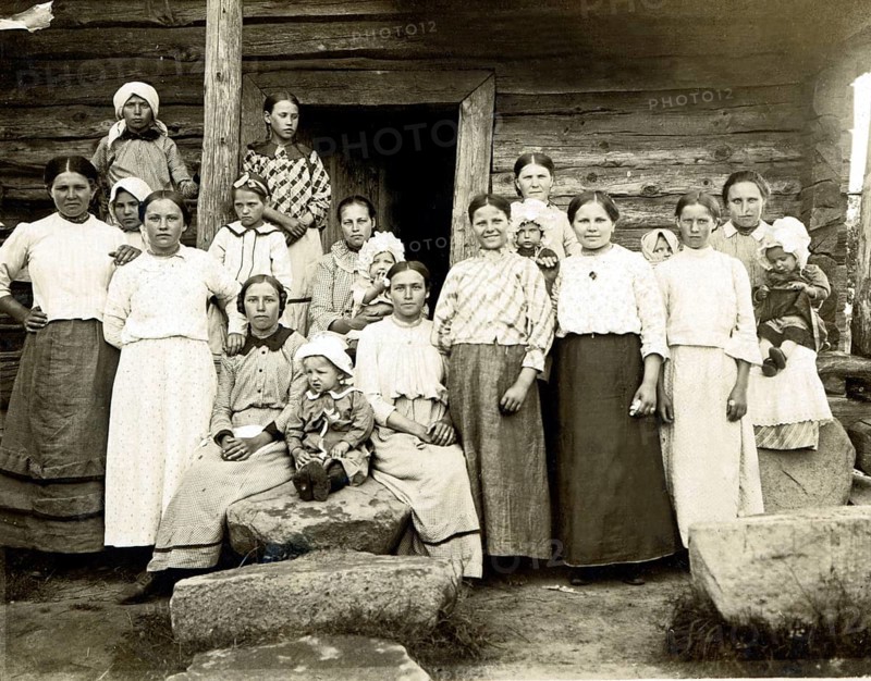 Large family in the countryside, 1920s, Group of woman and children in front of a wooden house, Black and white photo with traditional style, Historical photo