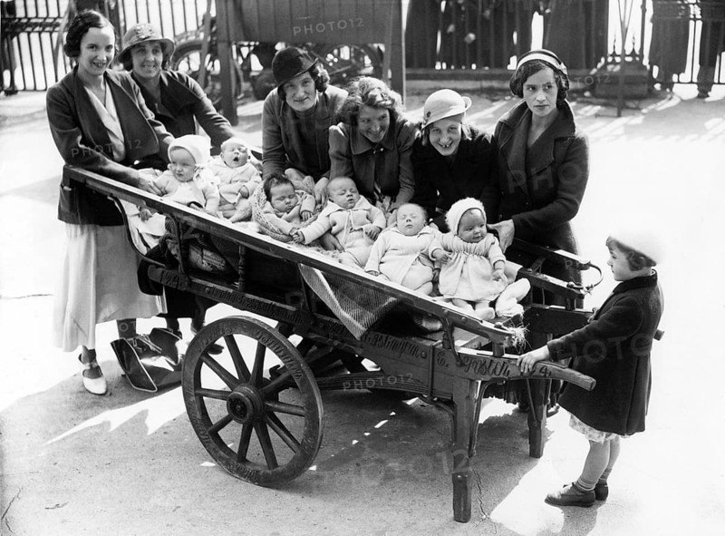 Cartload of babies, 1920s, woman with babies in carts standing on a street, historical photo