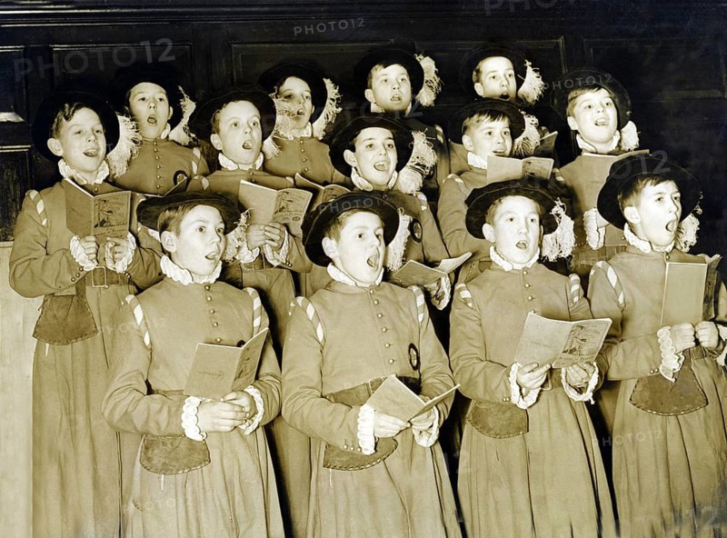 Traditional boys' choir, 1930s, group of children in historical costumes singing together in a choir. The scene appears harmonious and solemn, historical photo
