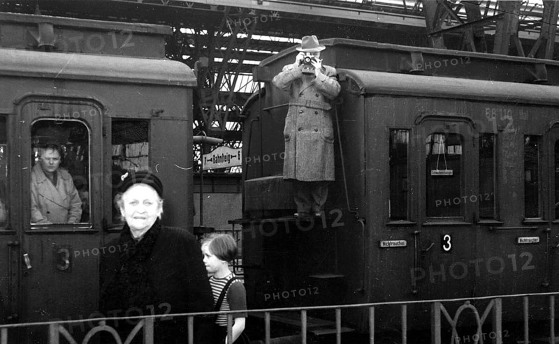 Train station hall photographer, 1930s, people on a platform, a man photographed from a carriage, historical photo