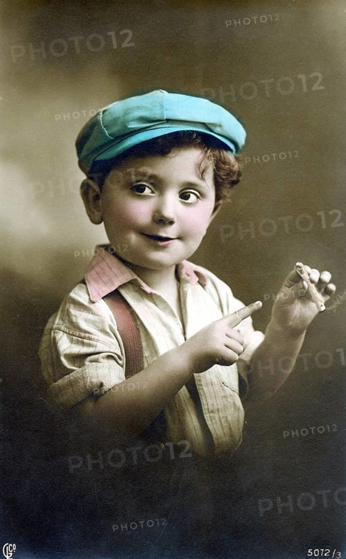 Little boy with a cigarette, 1930s, A boy in a colourful cap and shirt playfully holds a cigar and smiles, Historical photo